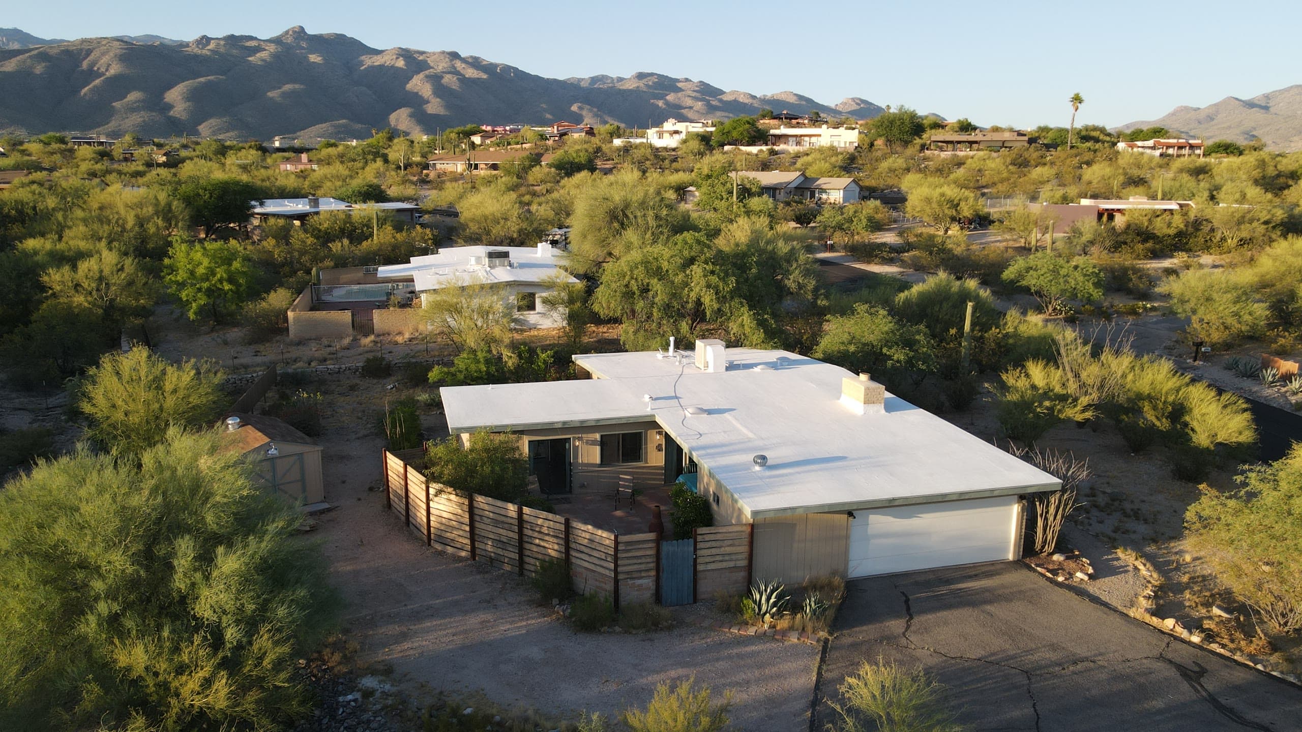 Mid-century flat-roof home in warm evening light with the Catalinas behind