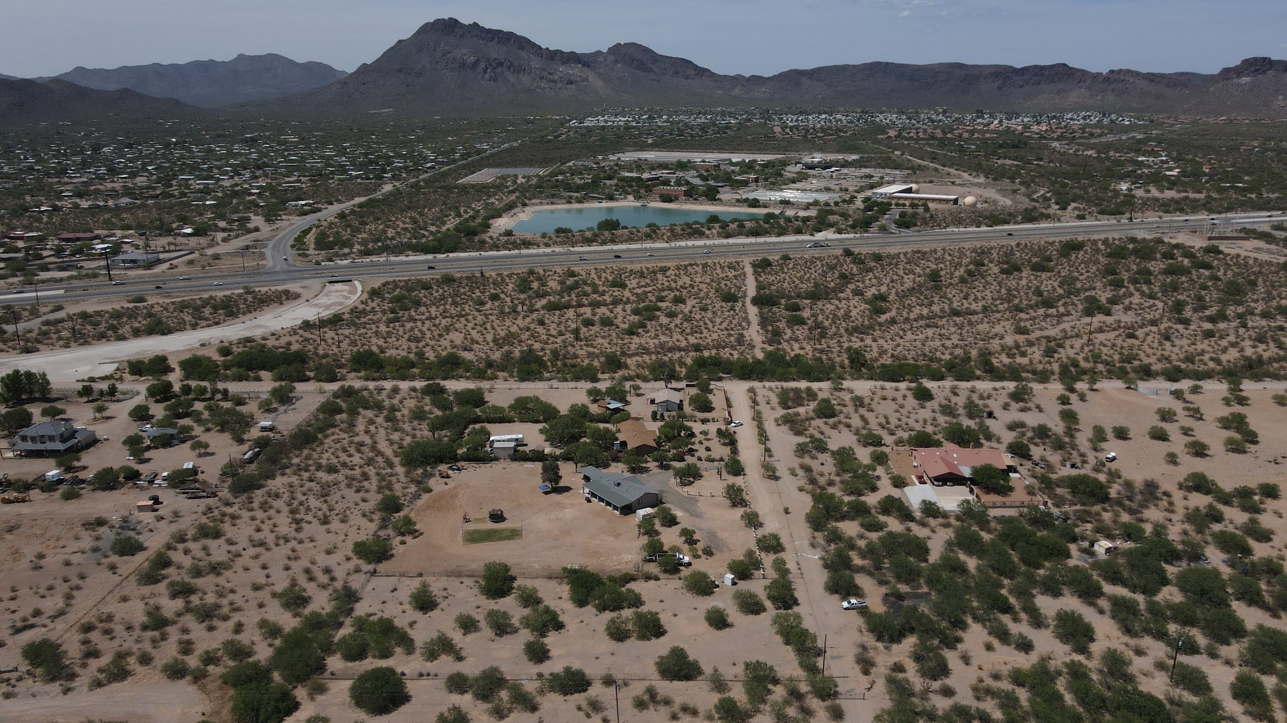 Desert acreage with scattered homes and mountains behind