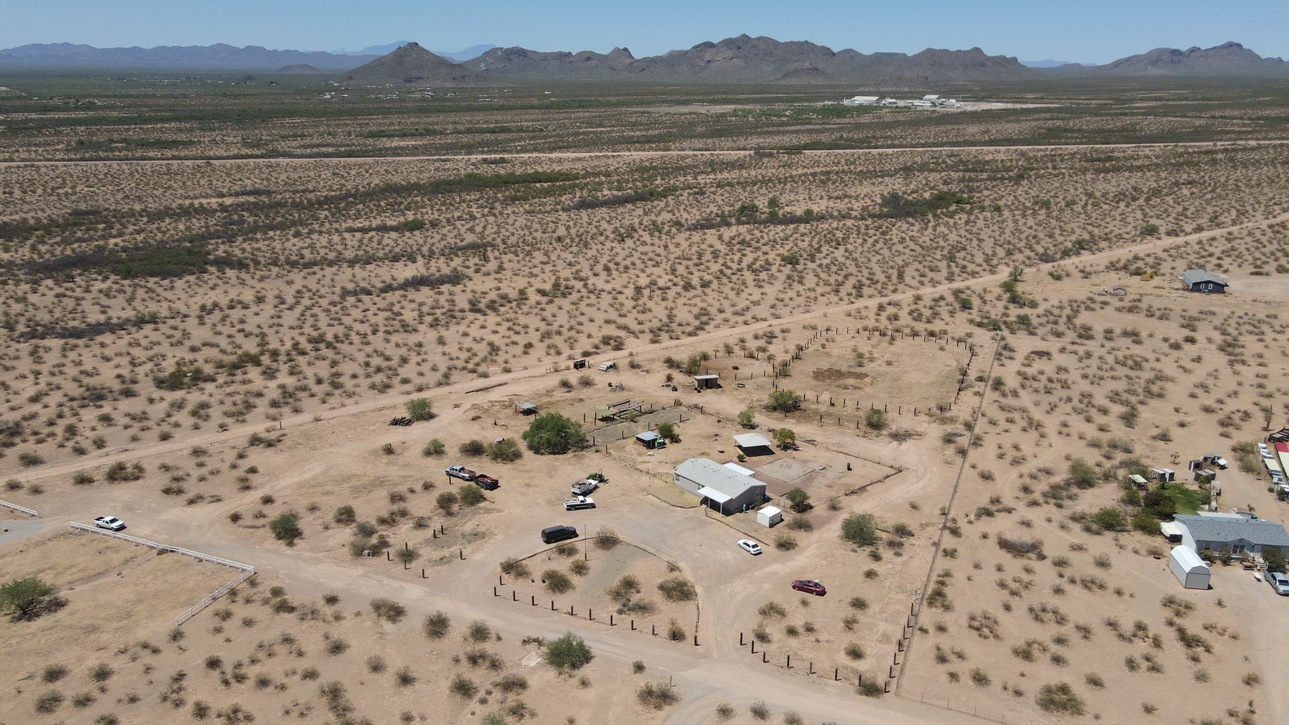 Wide view of horse property and dirt roads across open desert