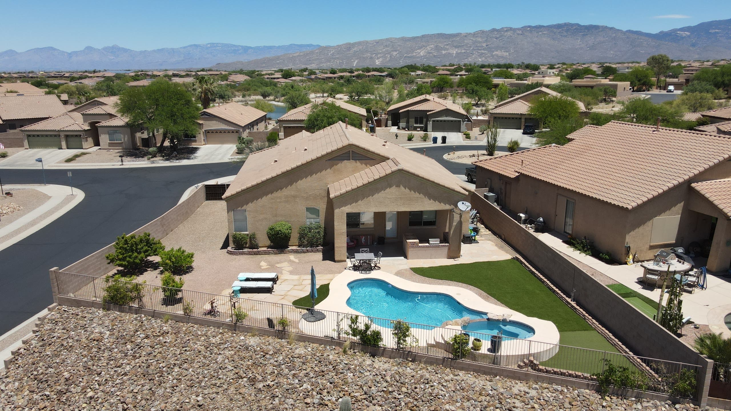 Backyard pool and artificial turf with the Rincon Mountains on the horizon